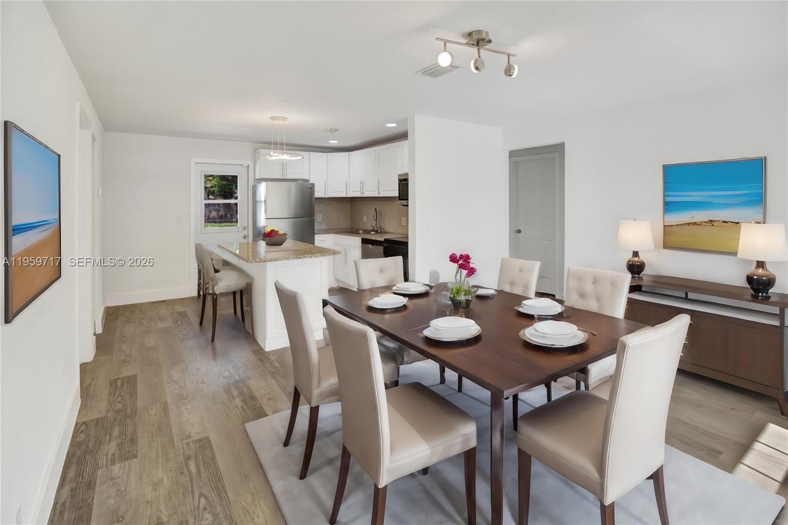 A bedroom features a bed with blue and gray bedding, a ceiling fan, and windows — 2311 Fletcher St, Hollywood FL 33020, HOLLYWOOD, FL
