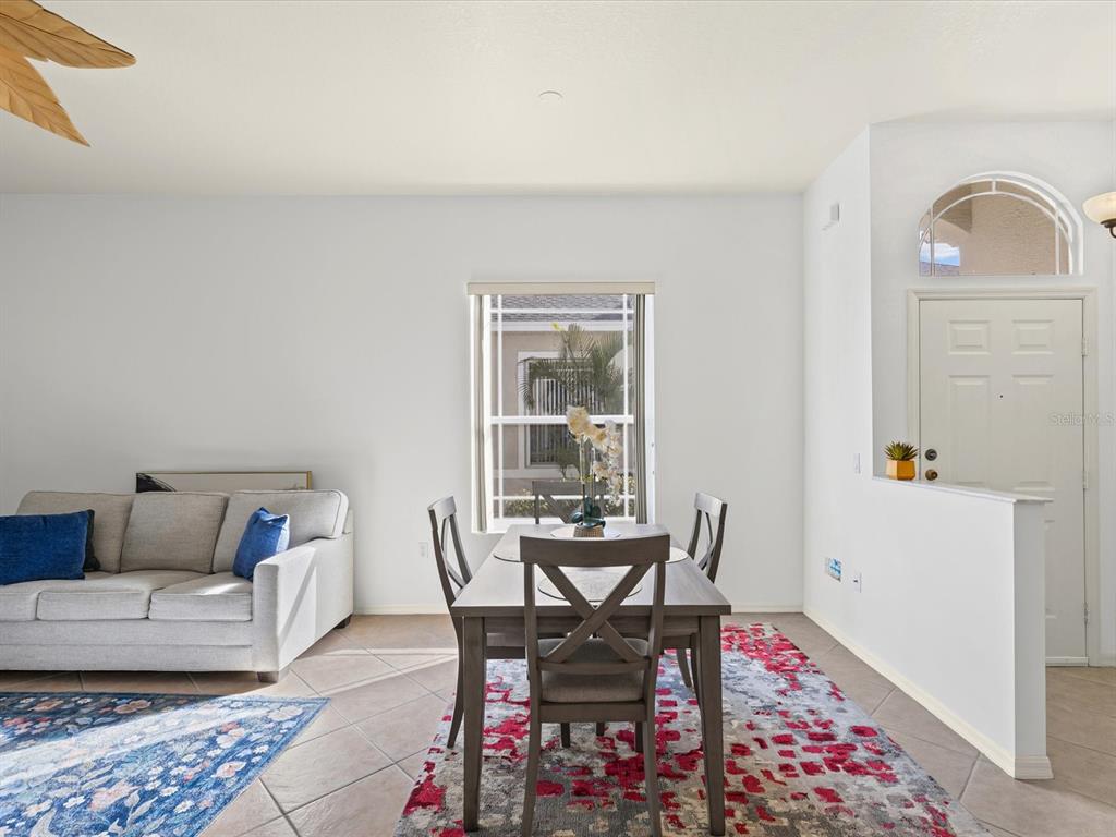 A dining area with a wooden table and chairs sits beside a living room sofa — 2649 TOTTENHAM DRIVE, NEW PORT RICHEY, FL