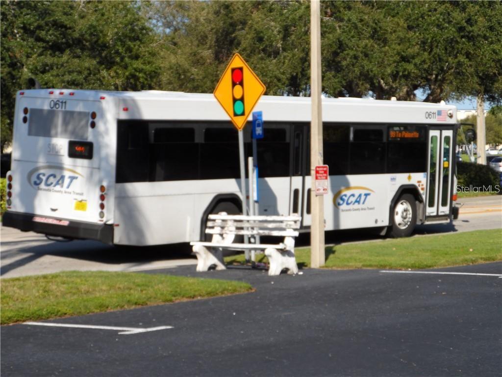A white Sarasota County Area Transit bus is parked near a bench and traffic sign — 2531 FLAMINGO BOULEVARD UNIT L25, BRADENTON, FL