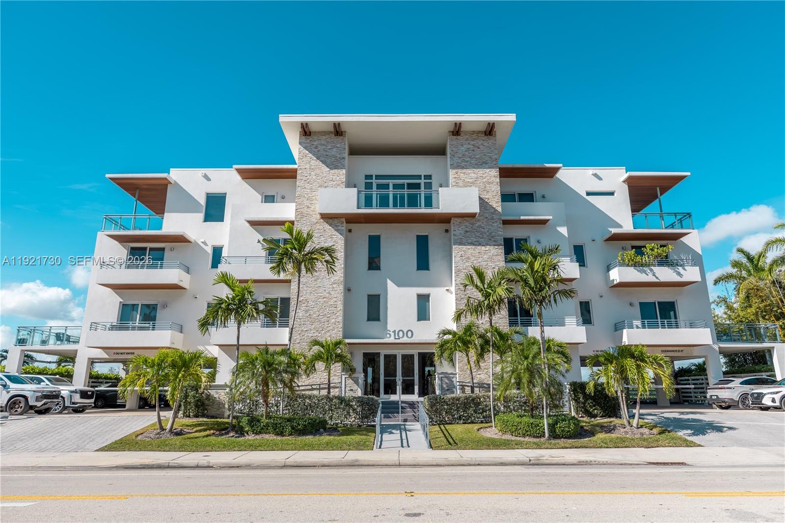 A modern multi-story apartment building features a stone facade, balconies, and palm trees — 6100 N Ocean Dr # 3N, Hollywood FL 33019, HOLLYWOOD, FL