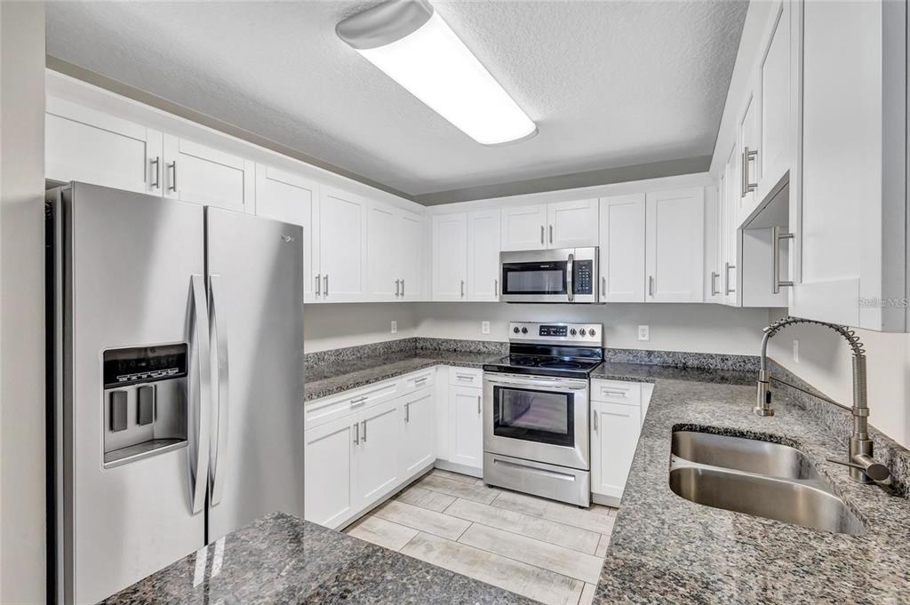A kitchen with white cabinets, stainless steel appliances, and granite countertops — 10413 SUMMERVIEW CIRCLE, RIVERVIEW, FL