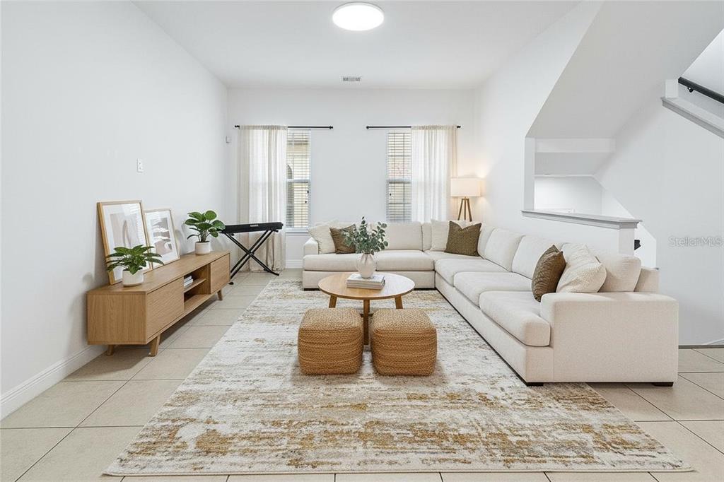 A home office features a gray sofa, a desk with a chair, and tile flooring — 940 LOBELIA DRIVE, LAKE MARY, FL