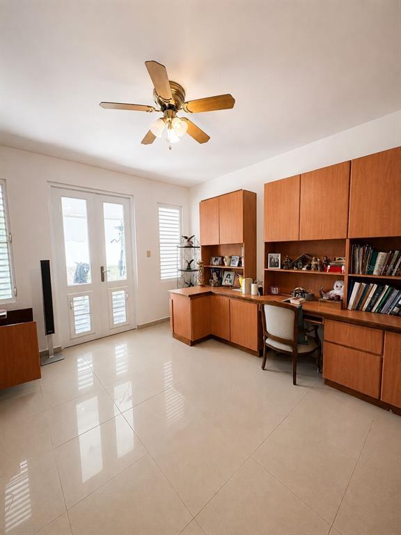 A home office features built-in wooden cabinetry, a desk, a ceiling fan, and tiled flooring — BO TALLABOA ALTA SOLAR 1 CARR 132 KM HM 16.3, PENUELAS, PR