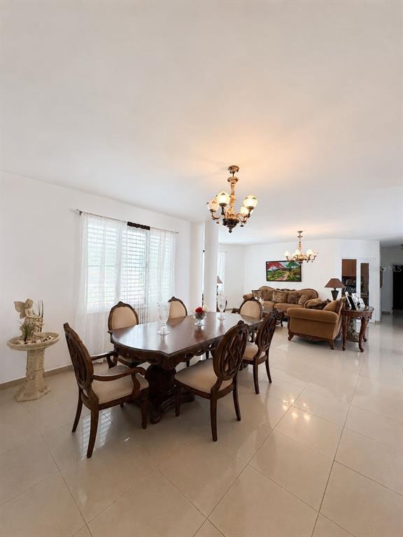 A dining area with a wooden table and chairs sits adjacent to a living room — BO TALLABOA ALTA SOLAR 1 CARR 132 KM HM 16.3, PENUELAS, PR