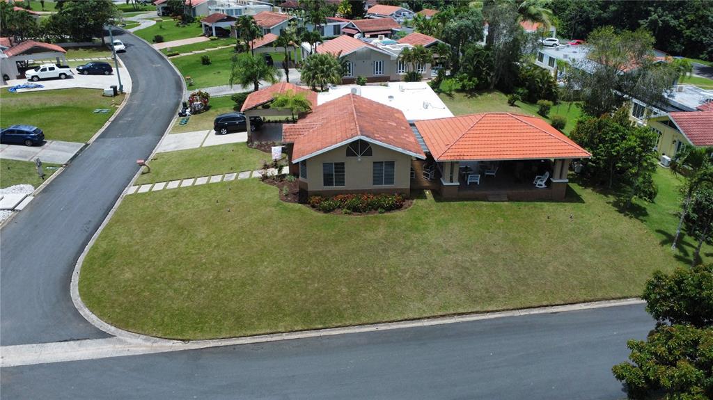 An aerial view shows a single-story house with a terracotta roof and a large lawn — 47 CAMINO DE LAS CASCADAS URB. SABANERA DE CIDRA, CIDRA, PR