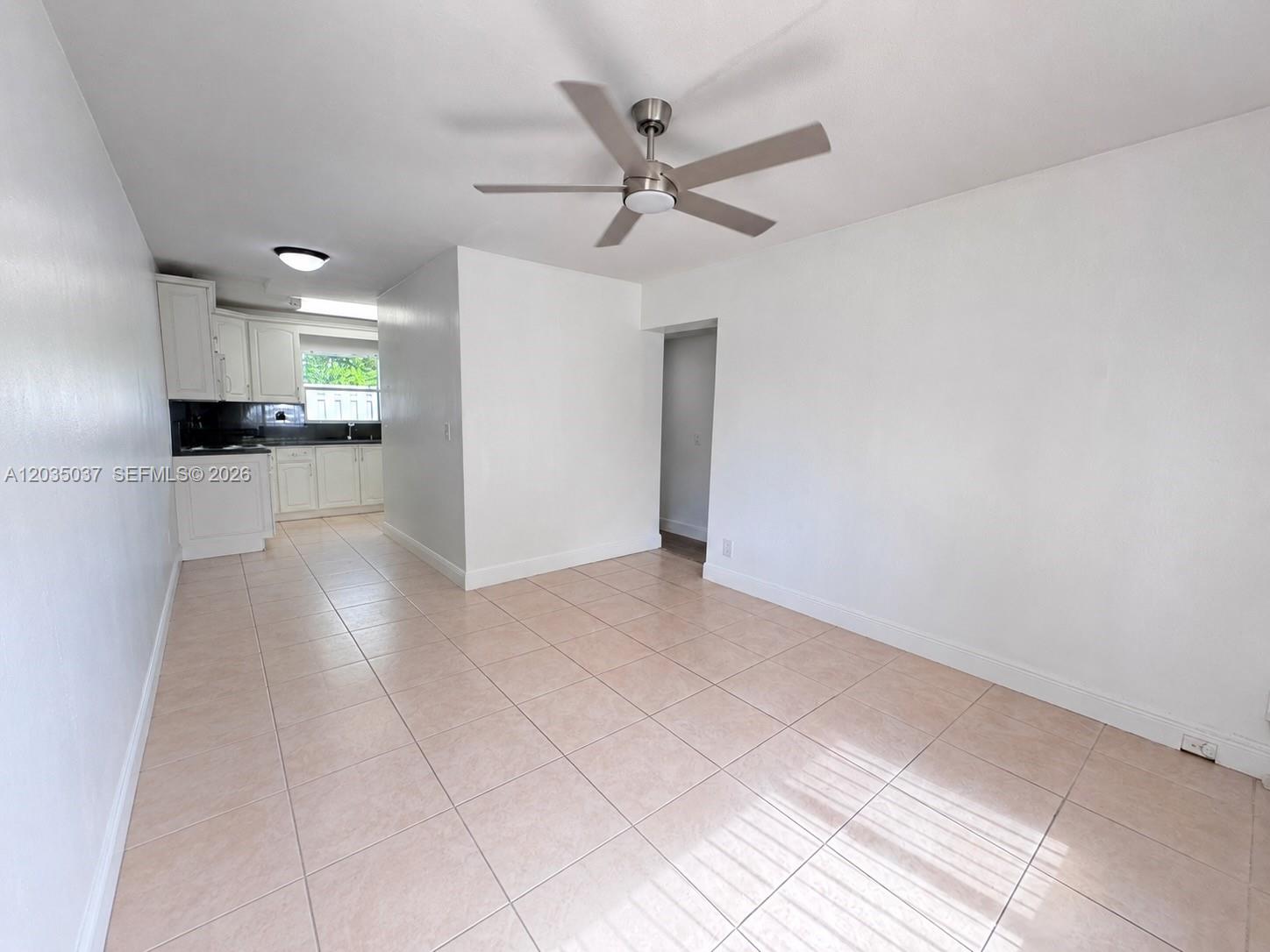 An open-concept dining area features light tile flooring, white walls, and a ceiling fan — 1801 NE 25th Ave # 3, Pompano Beach FL 33062, POMPANO BEACH, FL