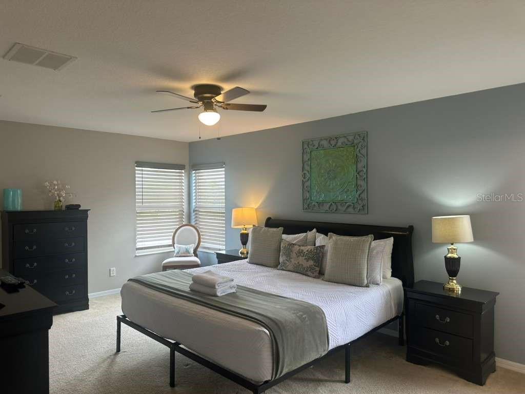 A bedroom features a bed with a dark frame, two nightstands, and a dresser — 109 MIRO DRIVE, DAVENPORT, FL