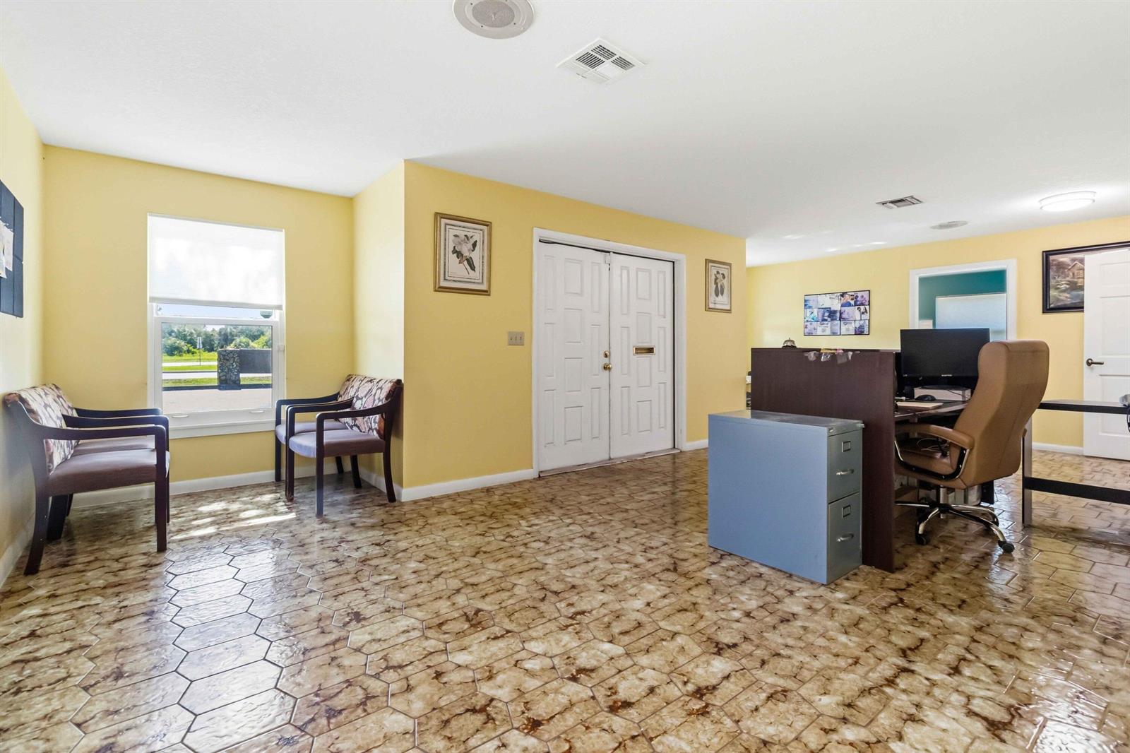 An office waiting area features yellow walls, patterned tile flooring, and a double-door entrance — 111 Scott Street, Melbourne FL 32901, MELBOURNE, FL
