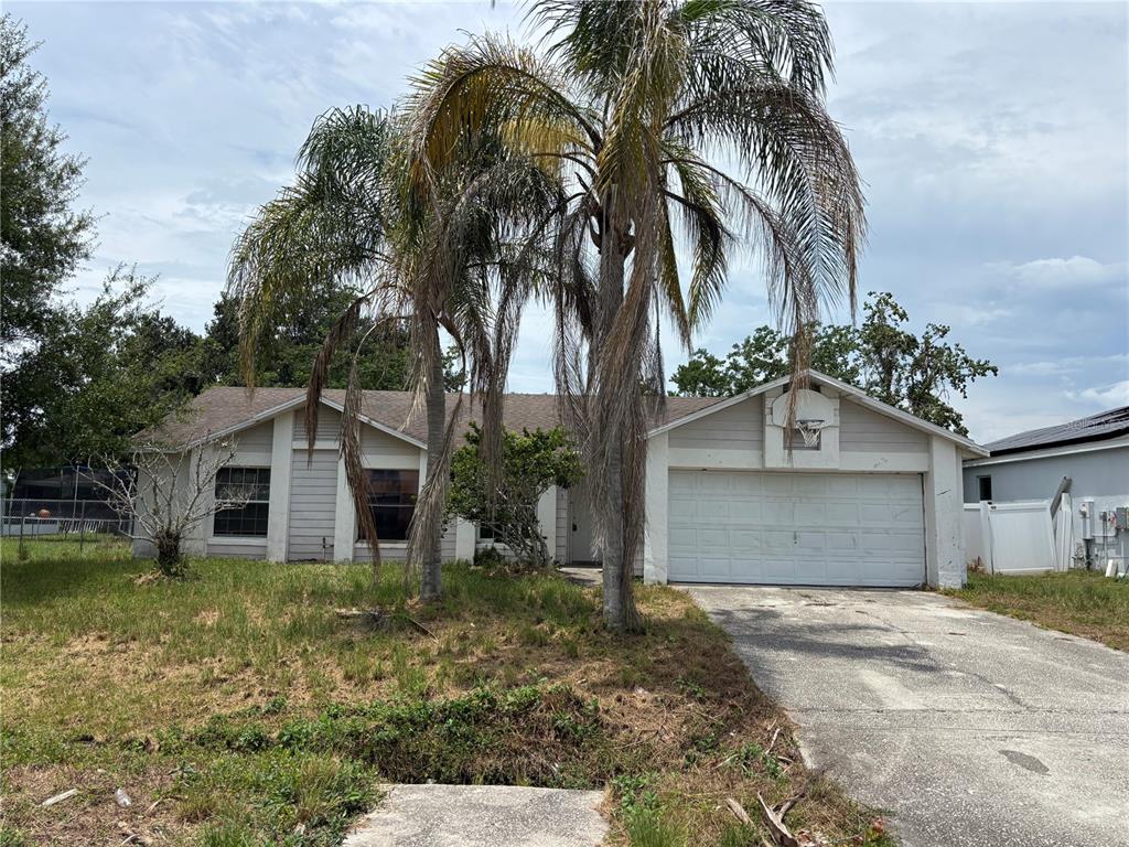 A single-story house with a white garage, palm trees, and a patchy lawn — 833 OGLETHORPE COURT, KISSIMMEE, FL