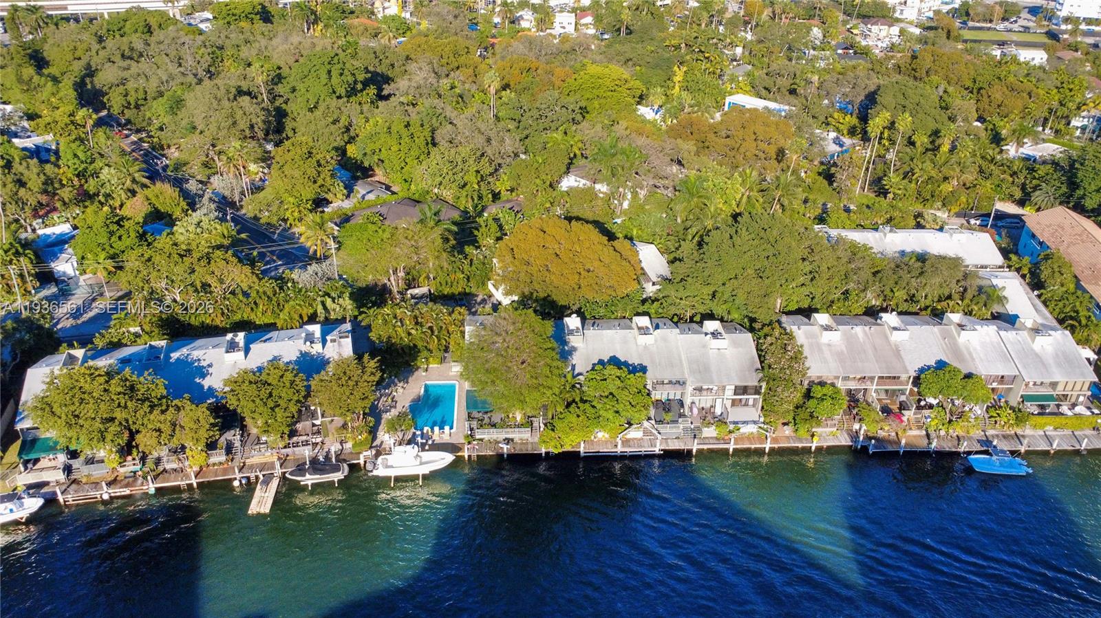 An aerial view shows waterfront townhomes with docks, boats, and a swimming pool — 1000 NW N River Dr # 20, Miami FL 33136, MIAMI, FL
