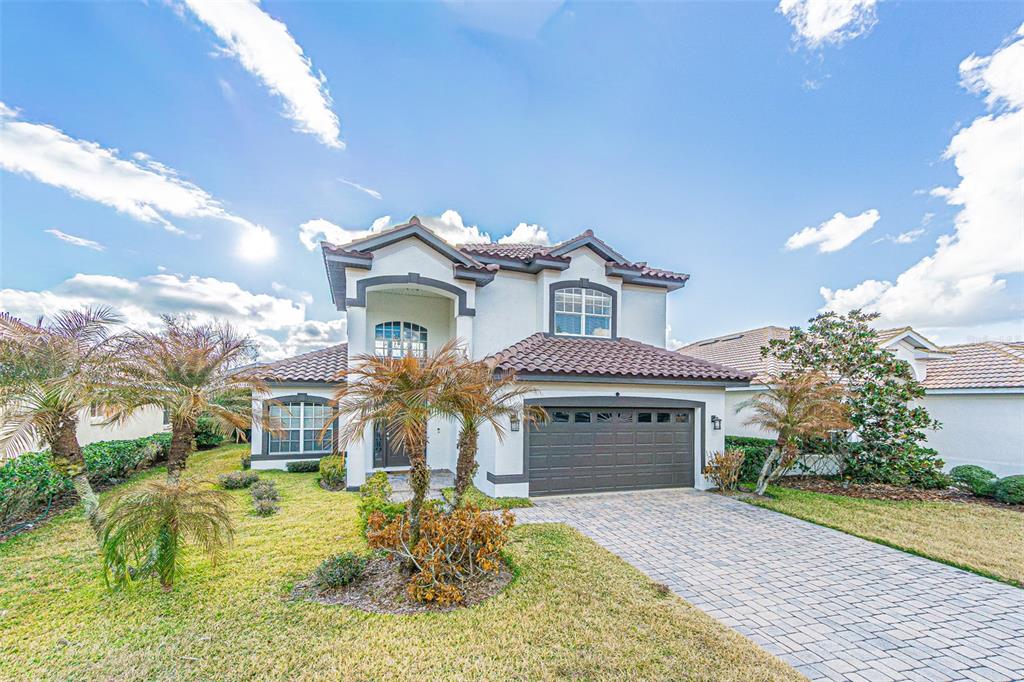 A two-story house with a tiled roof, a two-car garage, and a paved driveway — 10859 CORY LAKE DRIVE, TAMPA, FL