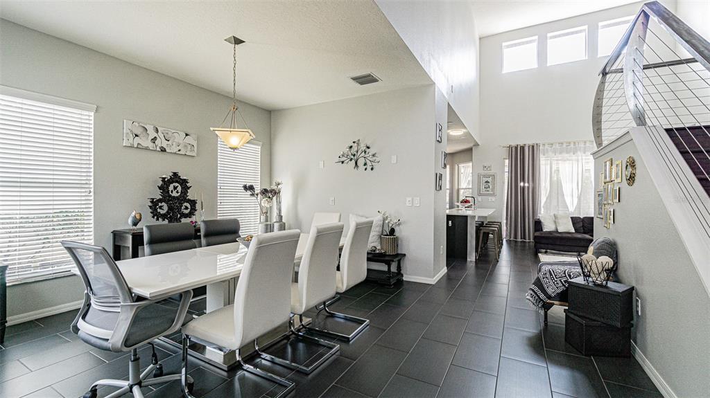 A dark front door with glass sidelights is flanked by two recessed wall niches with flowers — 10859 CORY LAKE DRIVE, TAMPA, FL