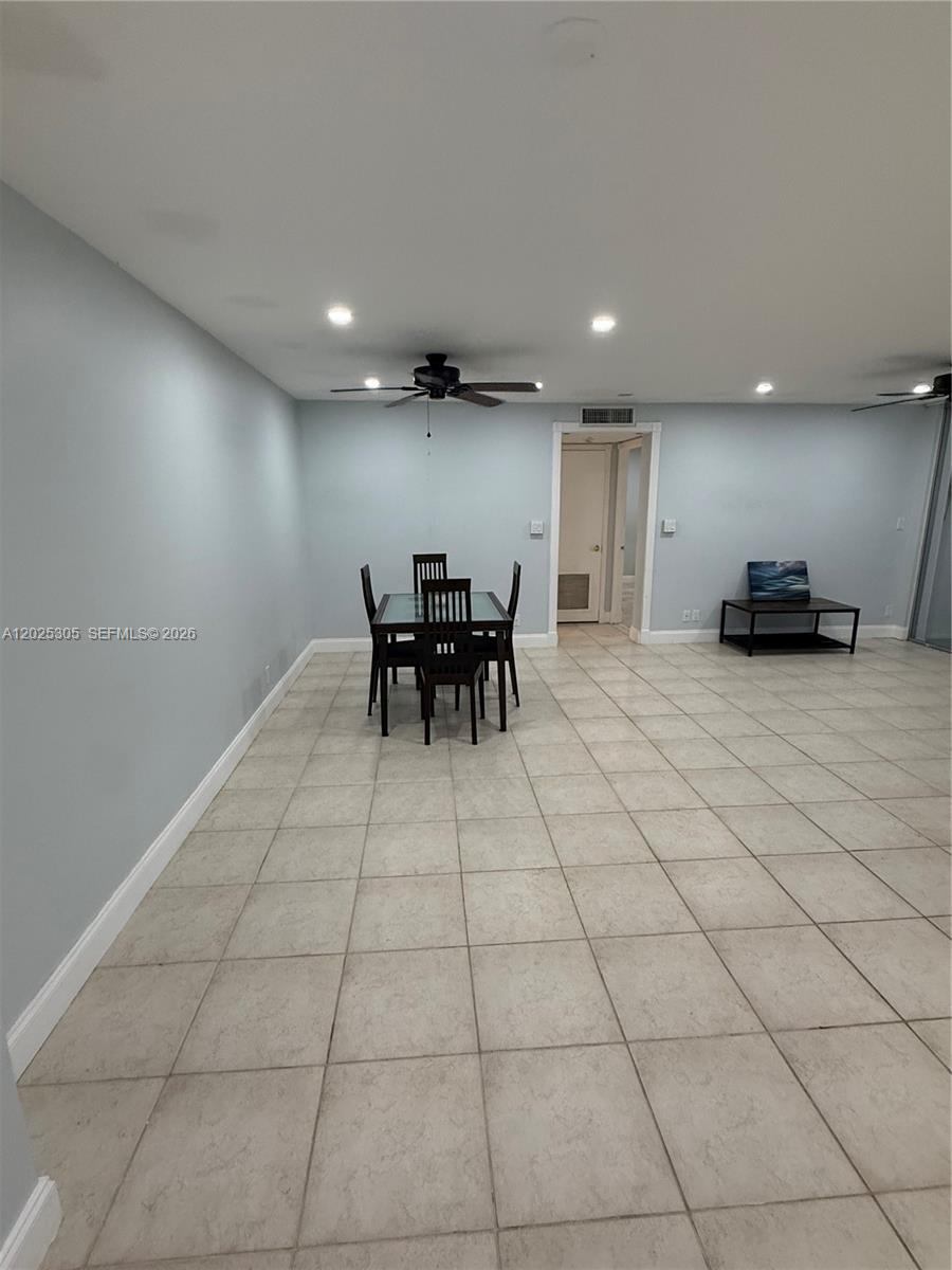 This room features light blue walls, a tile floor, and a dining set — 942 NE 199th St # 102, Miami FL 33179, MIAMI, FL
