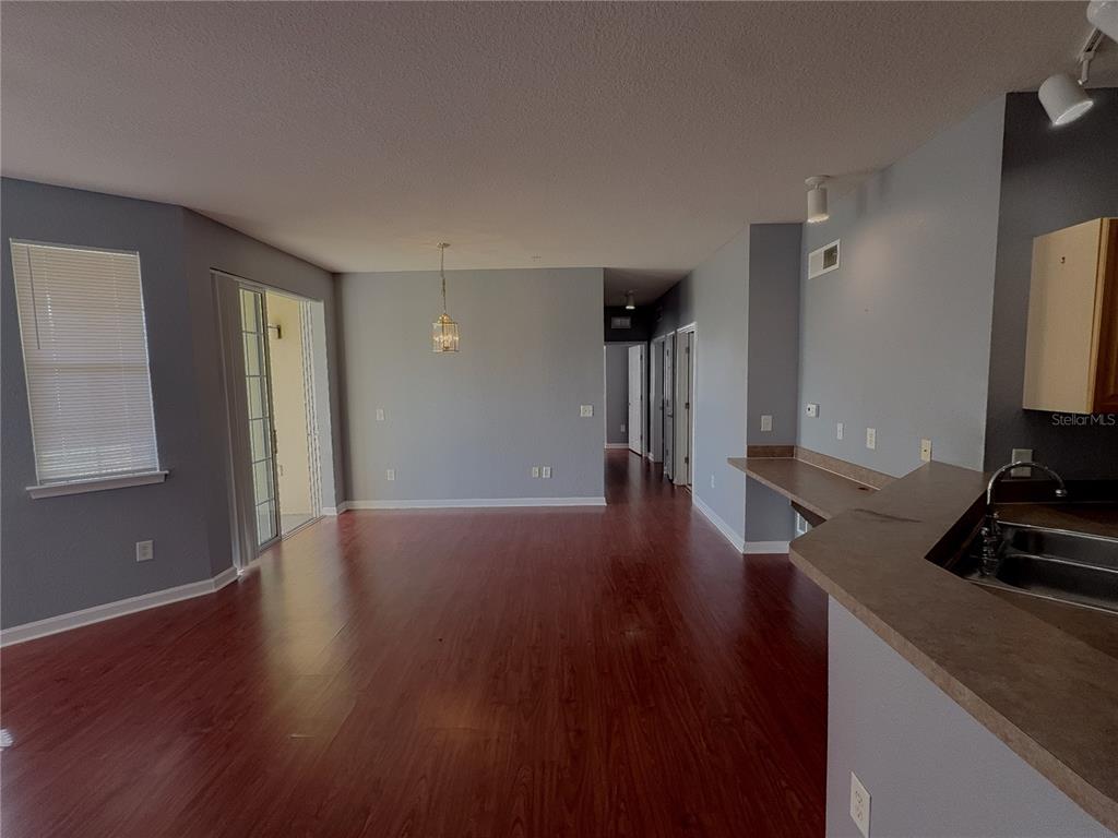 An open-concept living and dining area features wood-look flooring, light gray walls, and a kitchen — 204 TERRACE RIDGE CIRCLE UNIT 204, DAVENPORT, FL