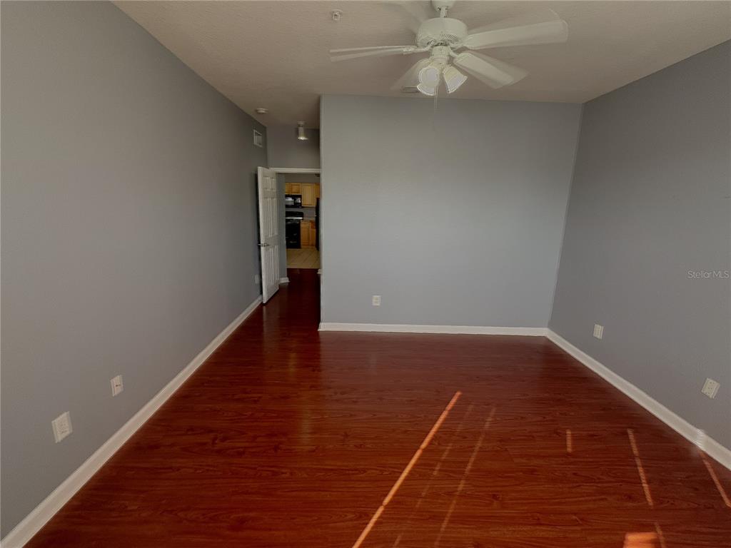An empty room with gray walls, hardwood floors, and a white ceiling fan — 204 TERRACE RIDGE CIRCLE UNIT 204, DAVENPORT, FL