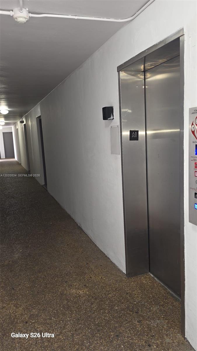 A hallway with a stainless steel elevator door and a textured floor — 8107 SW 72nd Ave # 423E, Miami FL 33143, MIAMI, FL