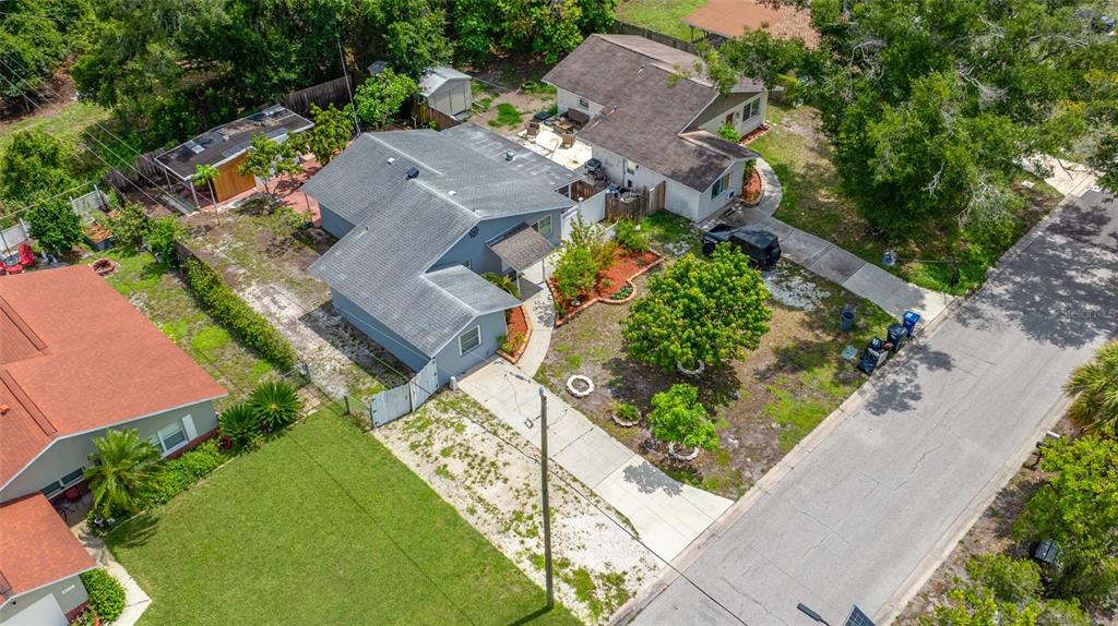An aerial view shows a gray house with a driveway and yard in a neighborhood — 4115 55TH AVENUE DRIVE E, BRADENTON, FL