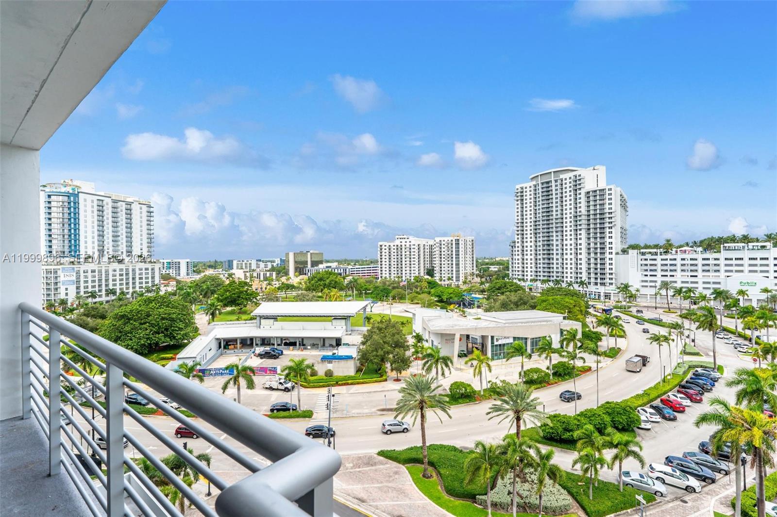 A high-angle view from a balcony overlooking a park, city buildings, and a parking lot — 1720 Harrison St # 9F, Hollywood FL 33020, HOLLYWOOD, FL
