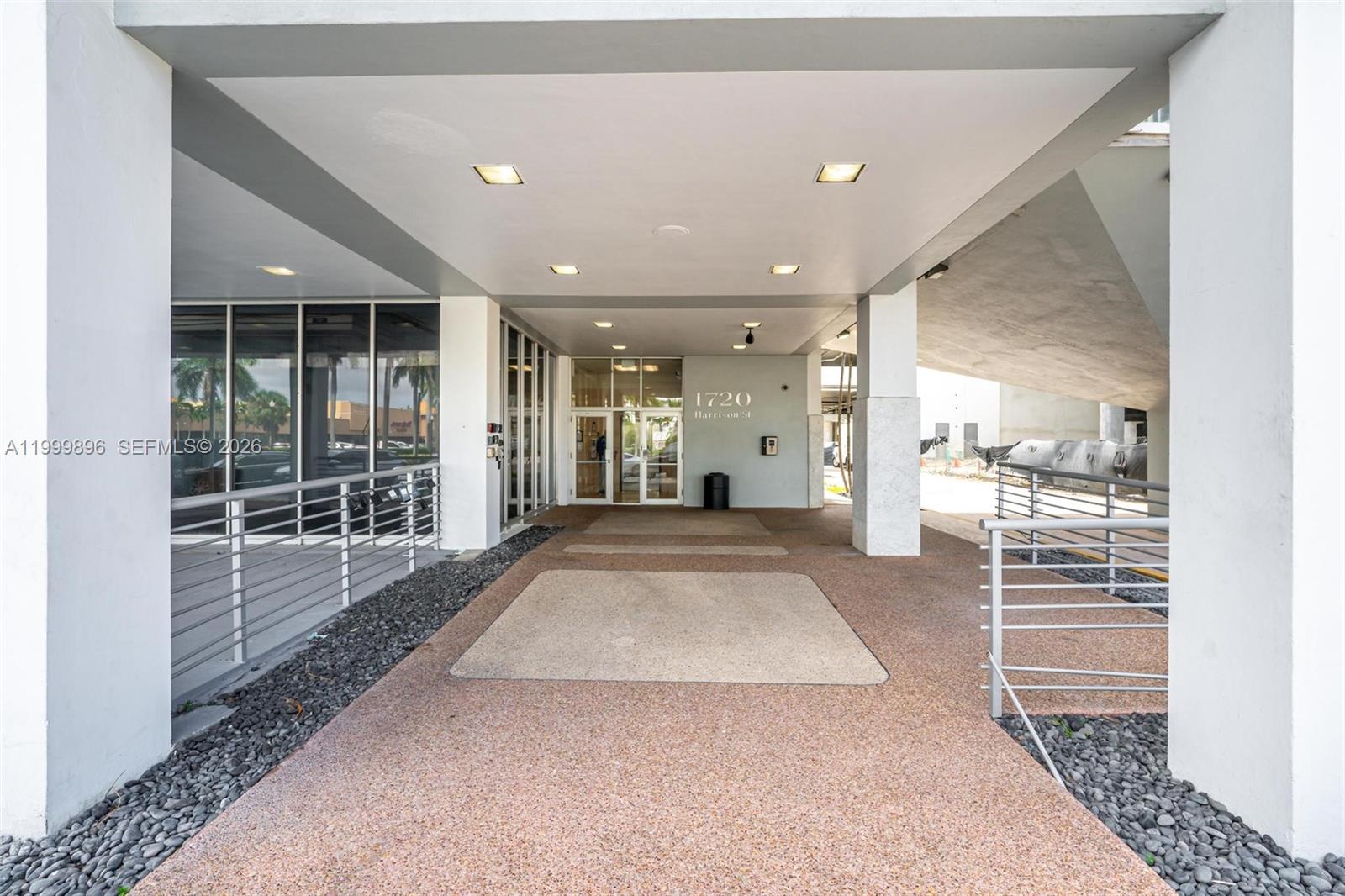 The exterior entrance features a covered walkway with recessed lighting and glass doors — 1720 Harrison St # 9F, Hollywood FL 33020, HOLLYWOOD, FL