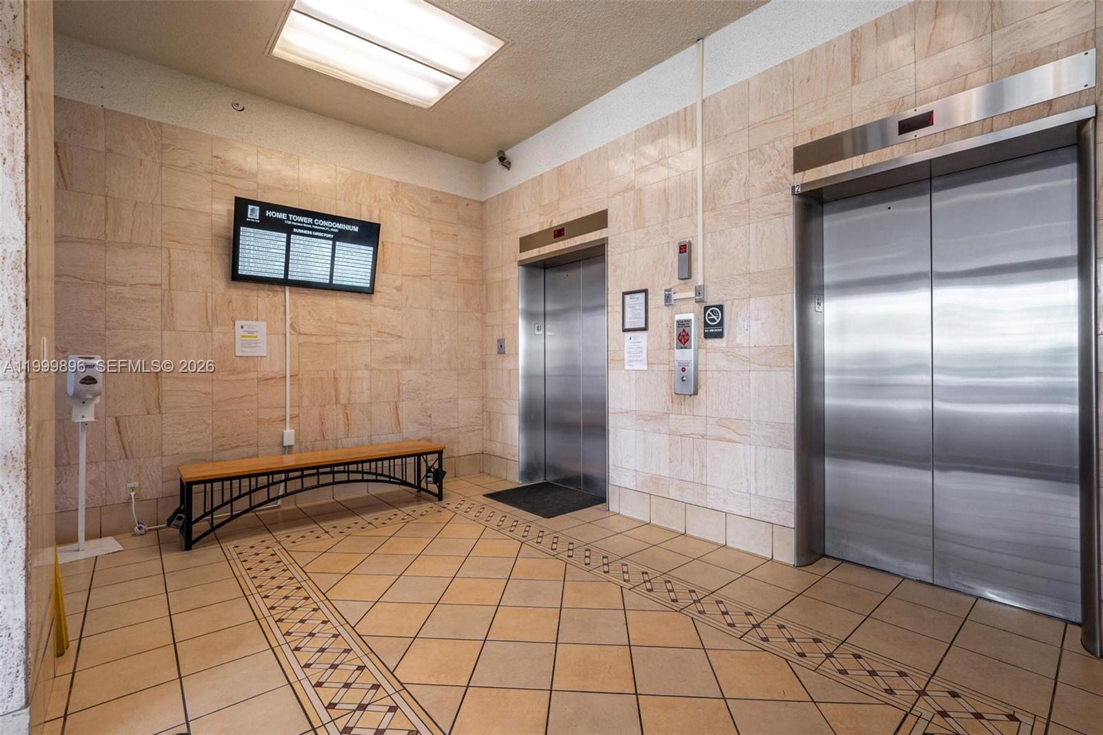 An elevator lobby features tiled walls, a bench, and two stainless steel elevator doors — 1720 Harrison St # 9F, Hollywood FL 33020, HOLLYWOOD, FL