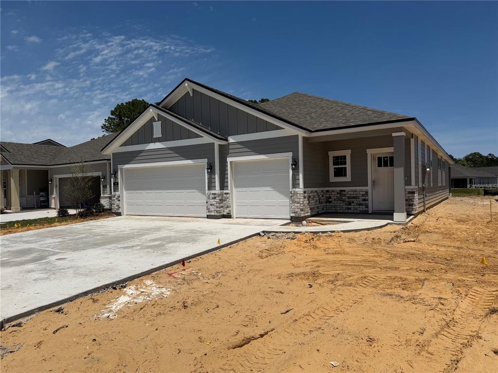 A newly constructed single-story house features a gray exterior, stone accents, and a two-car garage — 28 PERSEUS AVENUE, FLAGLER BEACH, FL