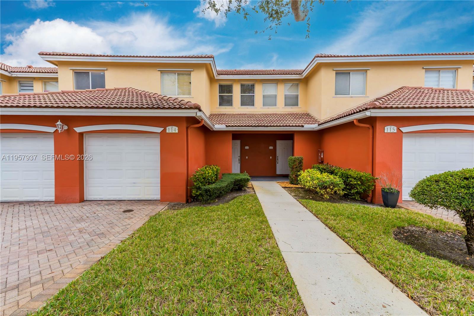 A two-story townhouse exterior features a two-car garage and a paved driveway — 7401 Palomino Dr # 1, Davie FL 33024, DAVIE, FL