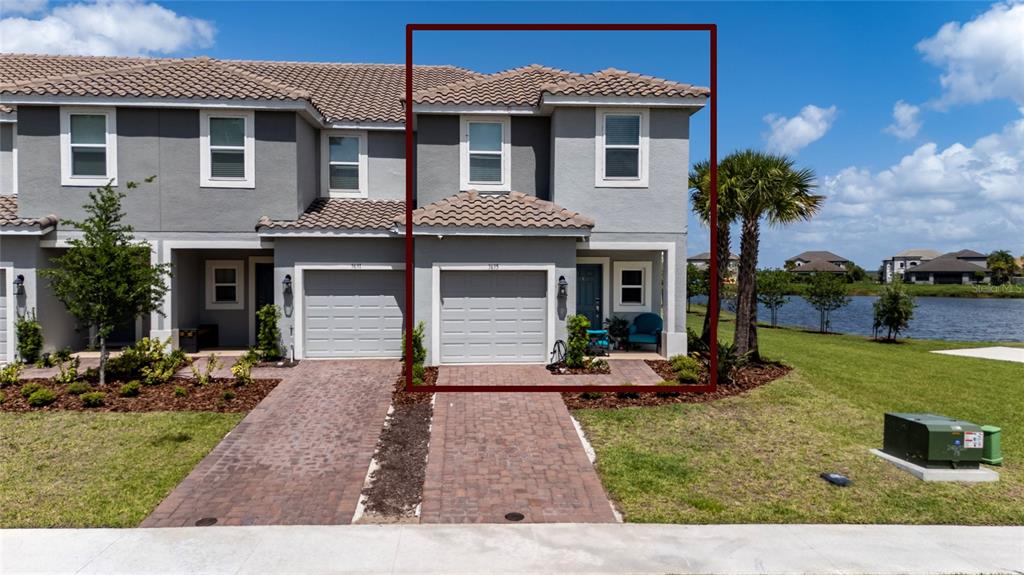 A two-story townhome with a gray stucco exterior, a tile roof, and a single-car garage — 3635 MAIN HARBOR DRIVE, KISSIMMEE, FL
