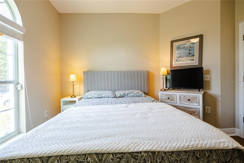 A bedroom features a bed with a striped headboard, two nightstands, and a television — 1908 W NASSAU STREET, TAMPA, FL