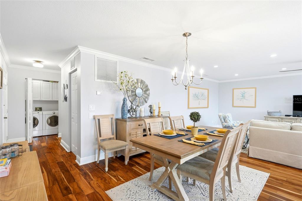 An open-concept living and dining area features hardwood floors, white cabinetry, and a sliding door — 6190 80TH STREET N UNIT 403, ST PETERSBURG, FL