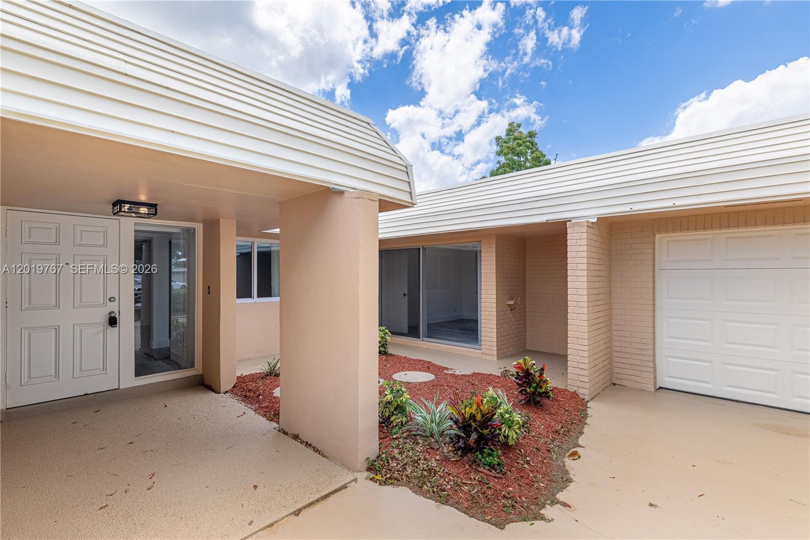 The exterior view shows a house entrance with a garage, a small garden, and columns — 5201 Yellow Pine Ln # 0, Tamarac FL 33319, TAMARAC, FL