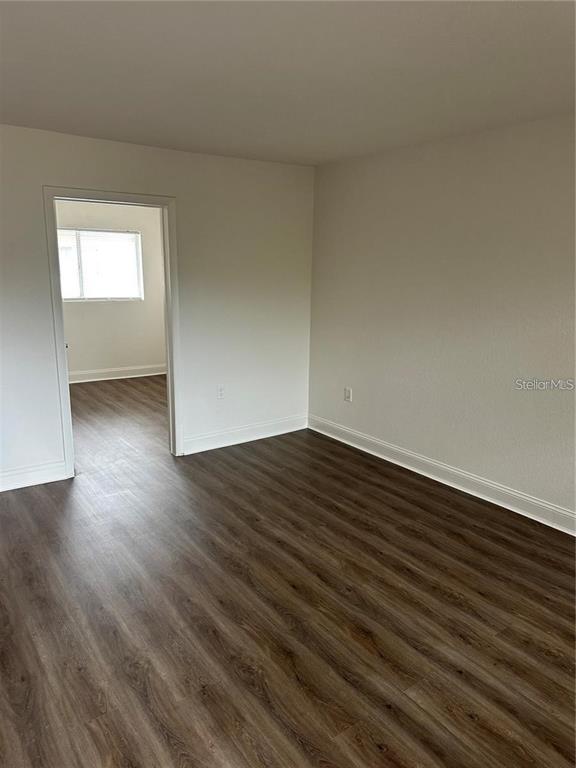 An empty room with wood-look flooring and a doorway leading to another room — 778 RIDENHOUR CIRCLE UNIT 778, ORLANDO, FL