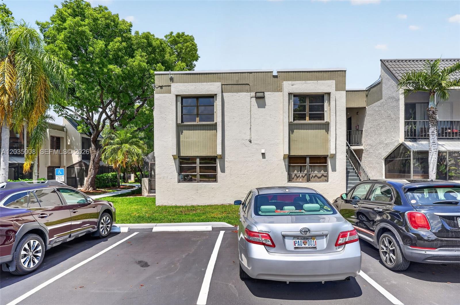 A two-story apartment building exterior with a parking lot in the foreground — 7917 SW 104th St # 201F, Miami FL 33156, MIAMI, FL