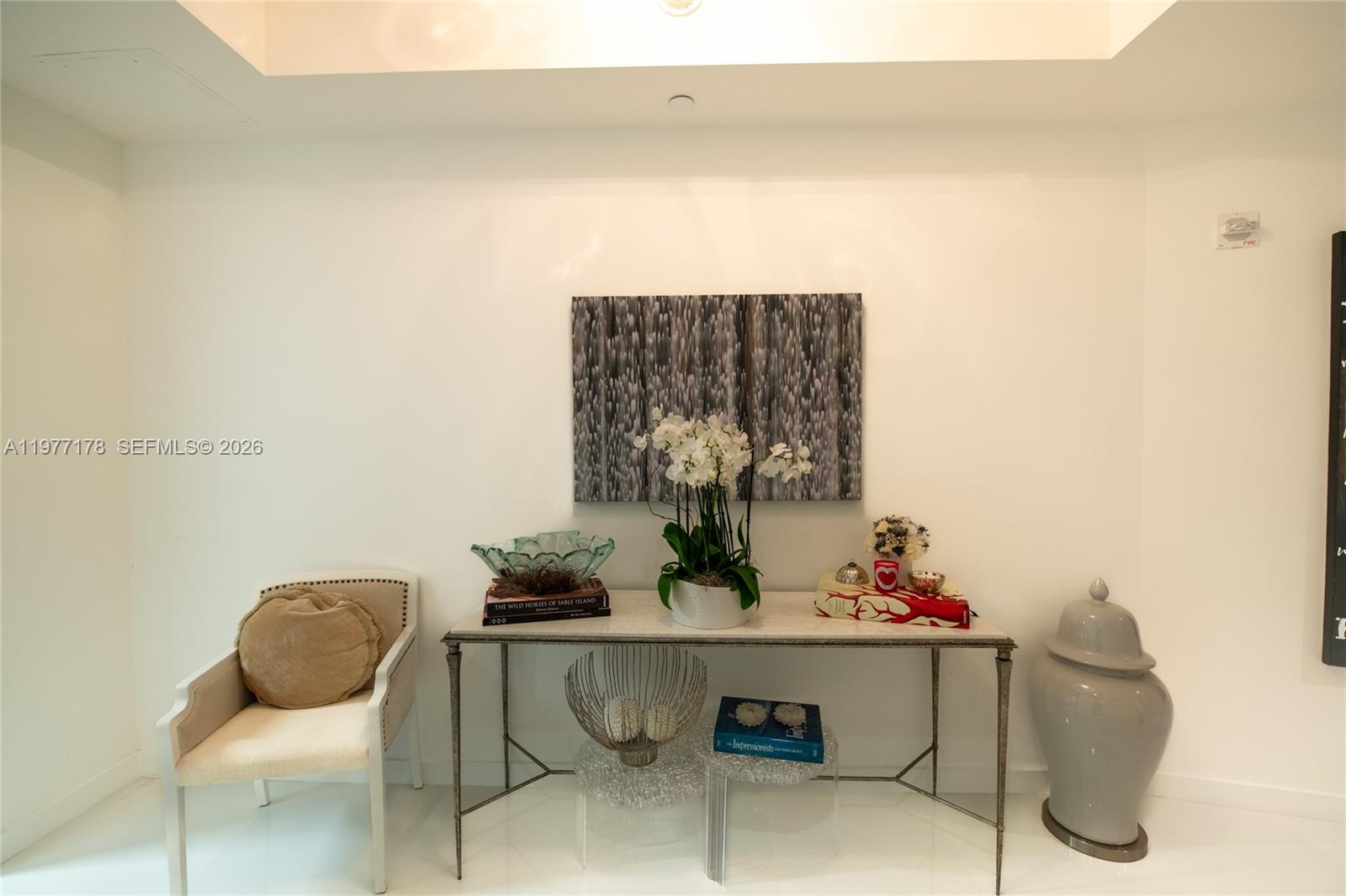 A console table with decor and a chair sit against a white wall — 851 NE 1st Ave # 811, Miami FL 33132, MIAMI, FL