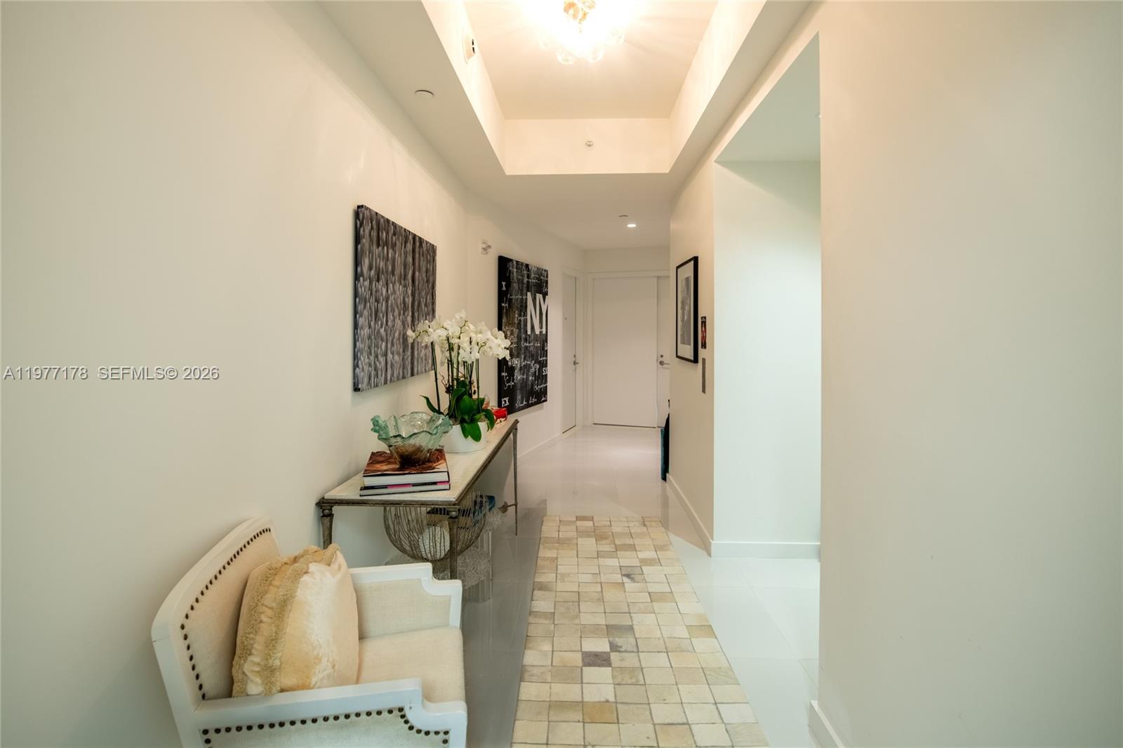 A bright hallway features a console table, a small armchair, and a tiled floor runner — 851 NE 1st Ave # 811, Miami FL 33132, MIAMI, FL