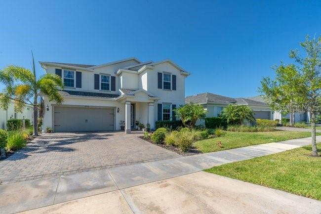 A two-story suburban house features a paved driveway, a two-car garage, and a palm tree — 42982 PARKSIDE COURT, PUNTA GORDA, FL