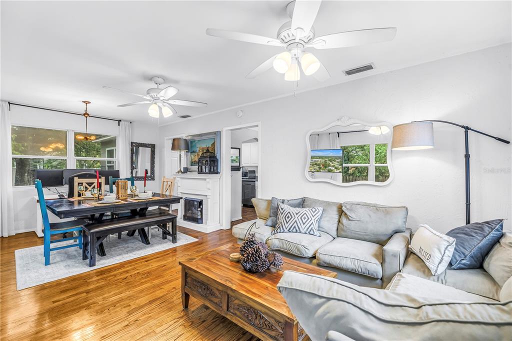 A living and dining area with hardwood floors, a ceiling fan, and a sectional sofa — 416 61ST AVENUE NE, ST PETERSBURG, FL