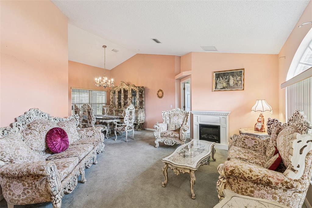 A living and dining room with ornate furniture, a fireplace, and peach-colored walls — 2270 CARSON LANE, DELTONA, FL