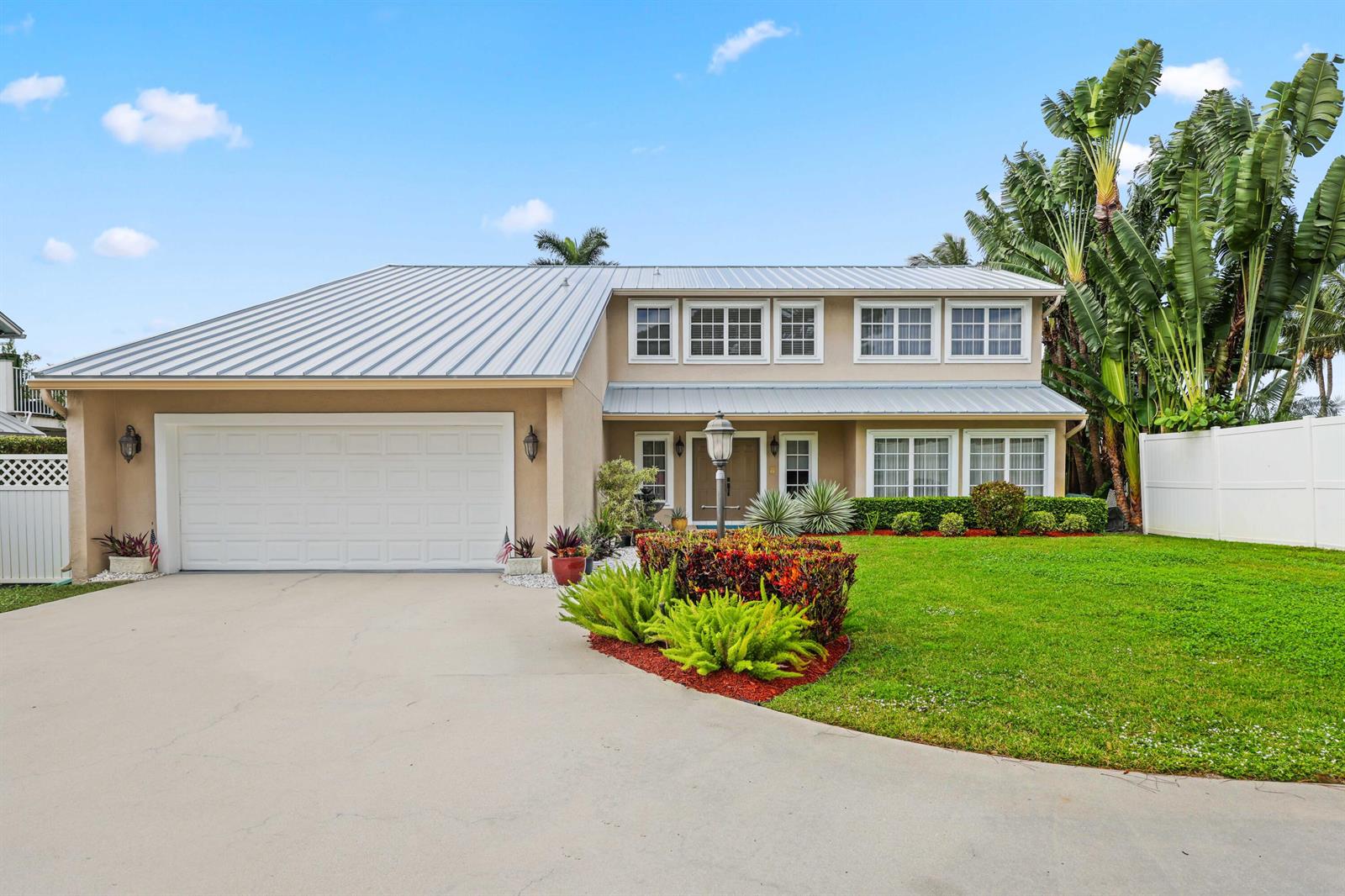 A two-story house with a metal roof, a two-car garage, and a landscaped front yard — 2097 Circle Place Drive, Lake Worth FL 33462, LAKE WORTH, FL