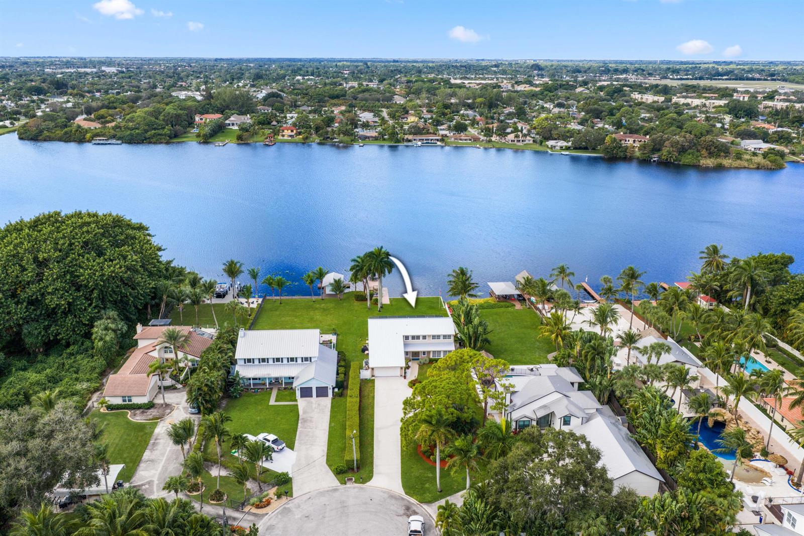An aerial view of a waterfront house with a large lawn and a white roof — 2097 Circle Place Drive, Lake Worth FL 33462, LAKE WORTH, FL