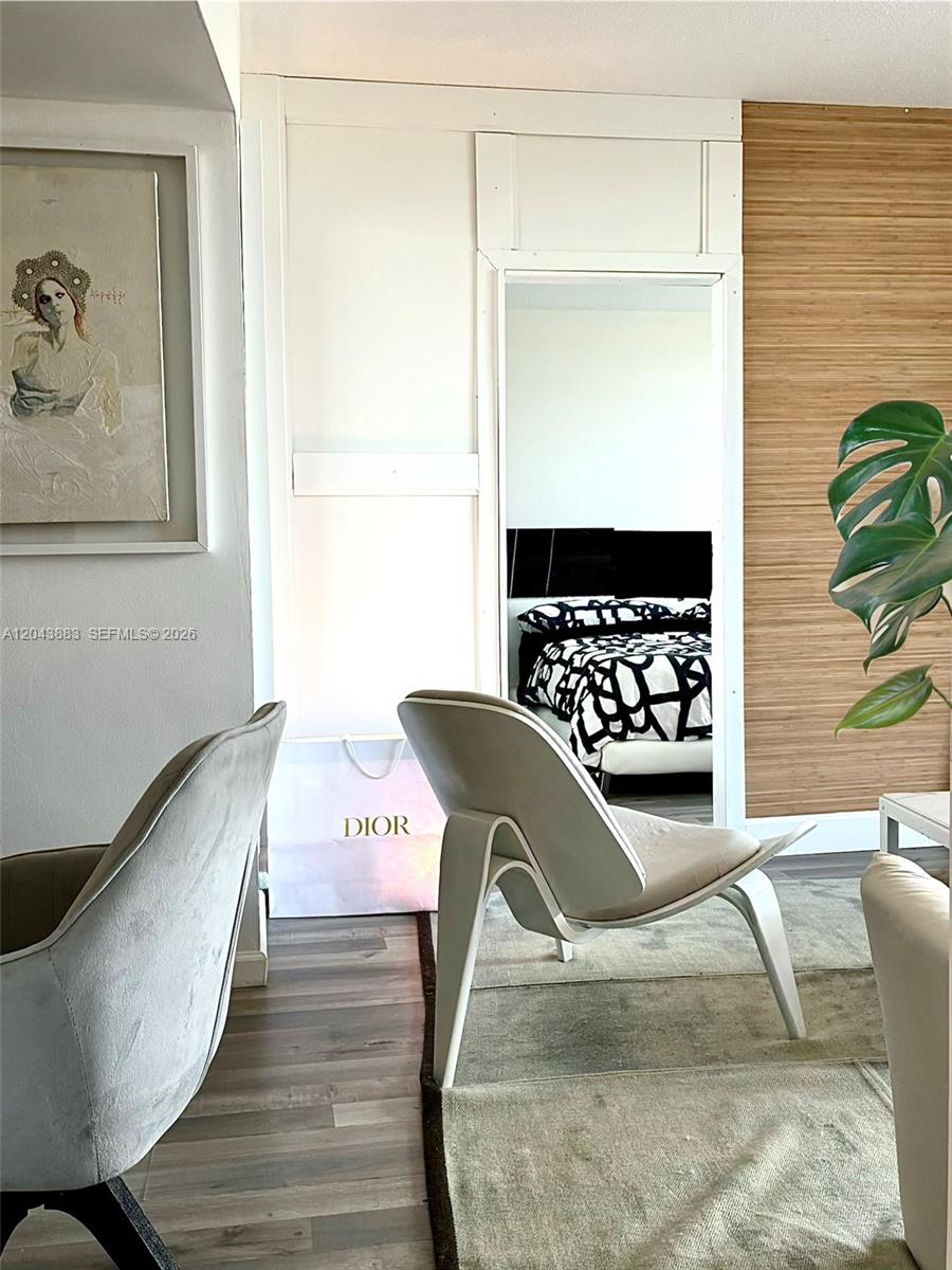 A living area features a modern chair, a Dior shopping bag, and a doorway view — 900 Bay Dr # 207, Miami Beach FL 33141, MIAMI BEACH, FL