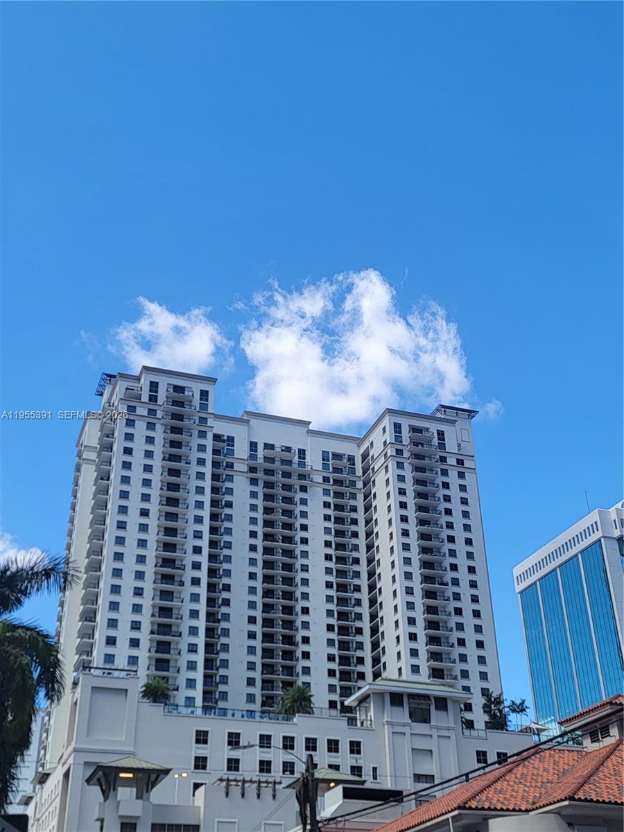A tall, white residential high-rise building stands against a clear blue sky — 999 SW 1st Ave # 2302, Miami FL 33130, MIAMI, FL