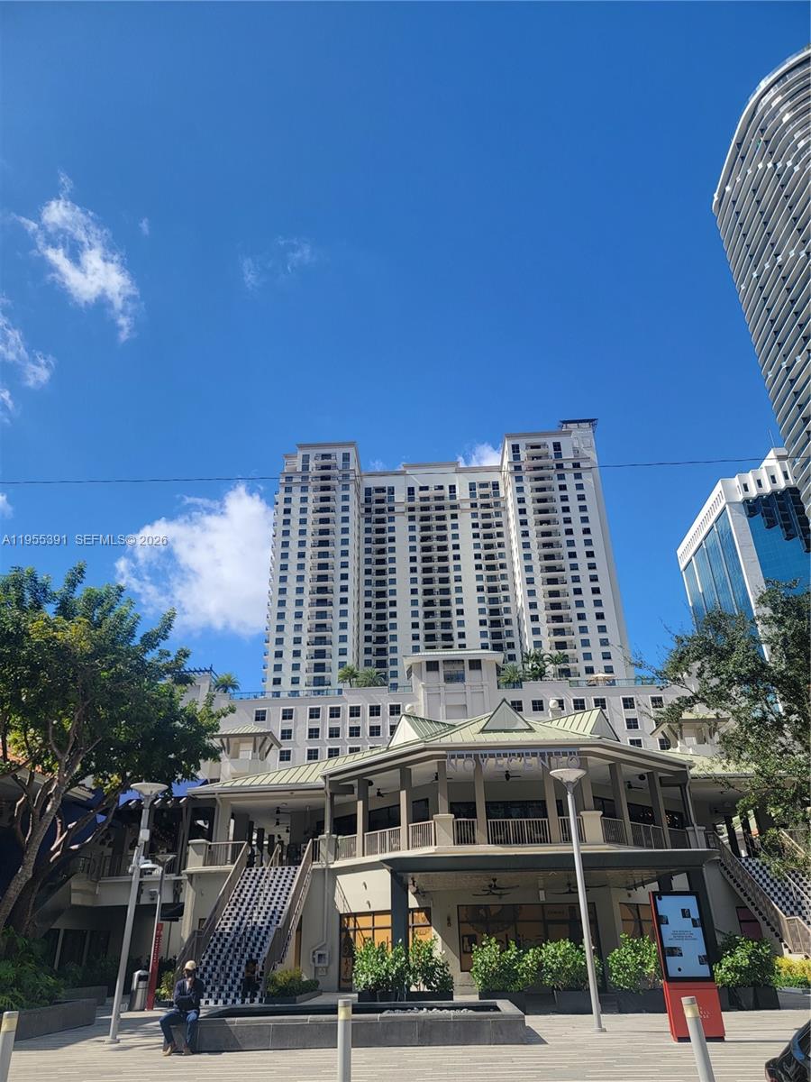 A tall residential building stands behind a multi-level commercial structure with a green roof — 999 SW 1st Ave # 2302, Miami FL 33130, MIAMI, FL