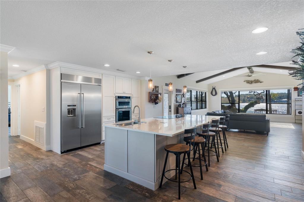 A modern kitchen with a large island, stainless steel appliances, and views of a lake — 17531 COUNTY ROAD 455, MONTVERDE, FL