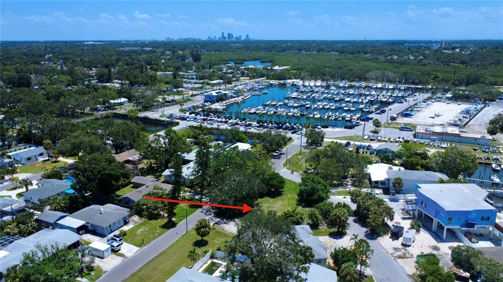 An aerial view shows a vacant lot marked by a red arrow near a marina — 4725 TRADE WINDS DRIVE S, GULFPORT, FL