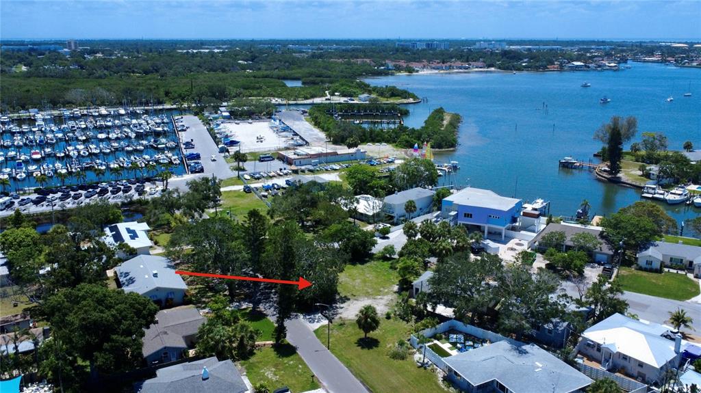 An aerial view shows a vacant lot near a marina and waterfront residential properties — 4725 TRADE WINDS DRIVE S, GULFPORT, FL