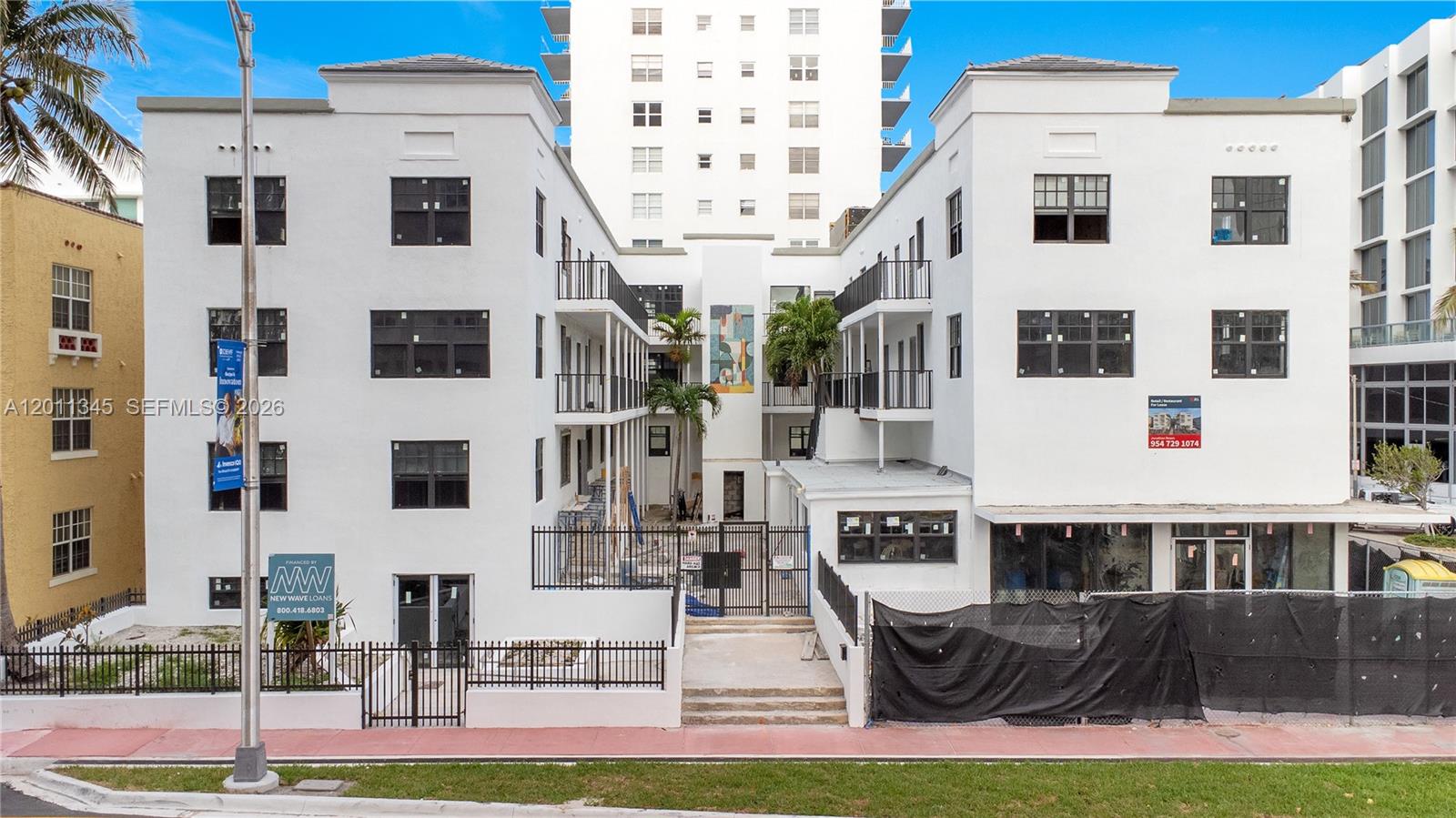 A white, multi-story apartment building with black-framed windows and a gated courtyard entrance — 2814 Collins Ave, Miami Beach FL 33140, MIAMI BEACH, FL