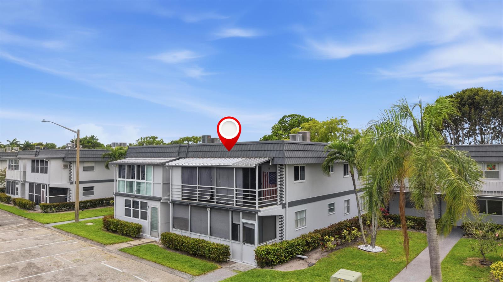 An exterior view of a two-story apartment building with a red location pin above — 376 Saxony H, Delray Beach FL 33446, DELRAY BEACH, FL