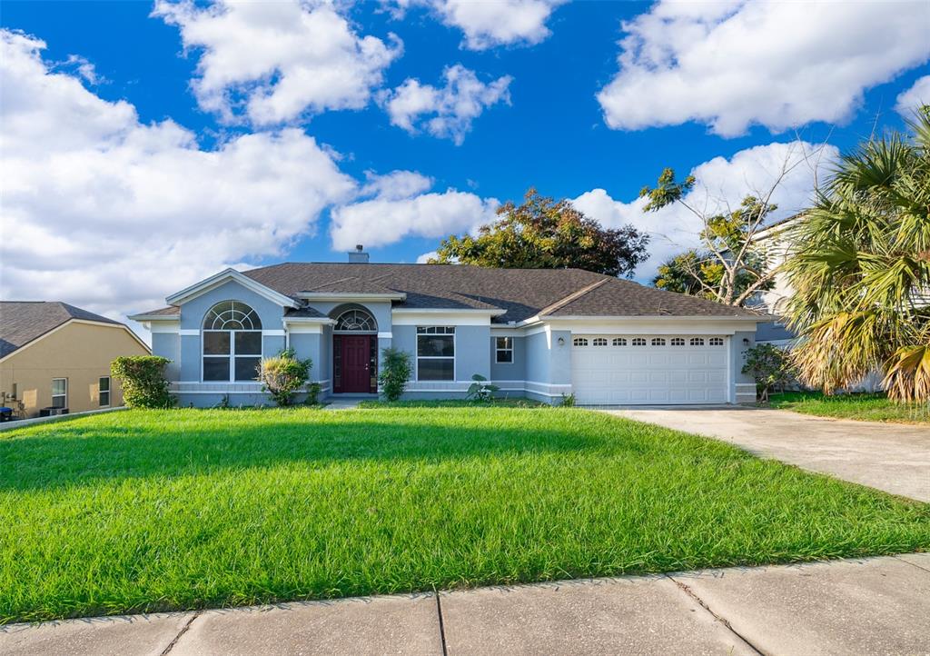 A single-story house with a light blue exterior, a two-car garage, and a front lawn — 7304 HIGH LAKE DRIVE, ORLANDO, FL