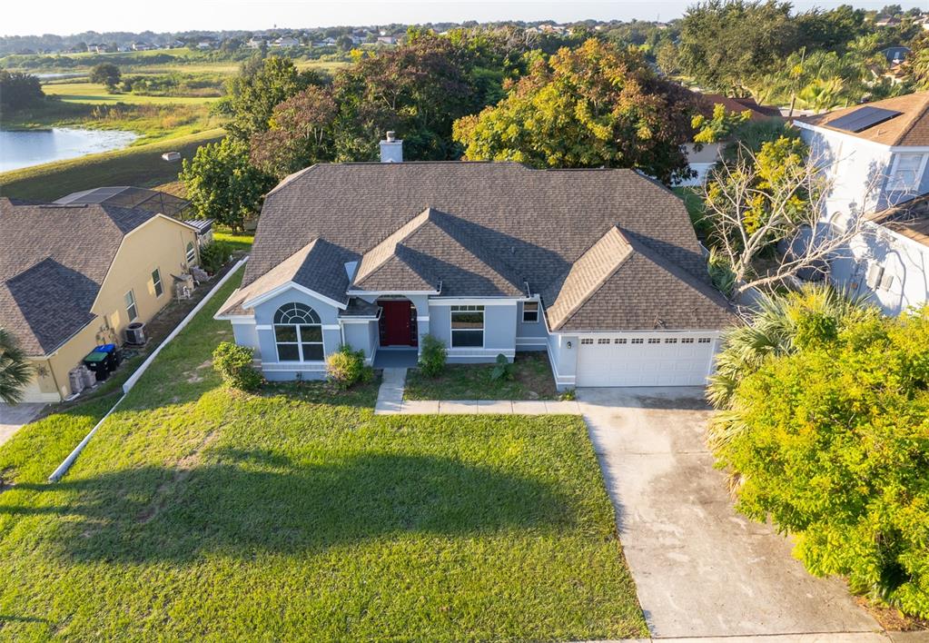 An aerial view of a single-story suburban house with a gray roof and driveway — 7304 HIGH LAKE DRIVE, ORLANDO, FL
