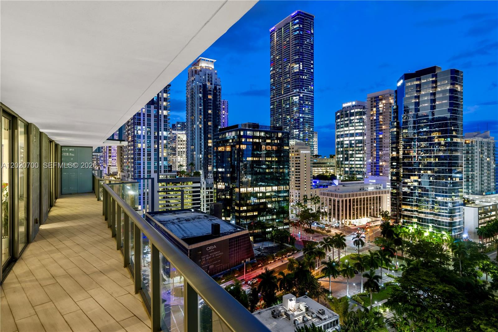 A balcony with glass railings overlooks a city skyline at twilight — 1300 S Miami Ave # 1405, Miami FL 33130, MIAMI, FL